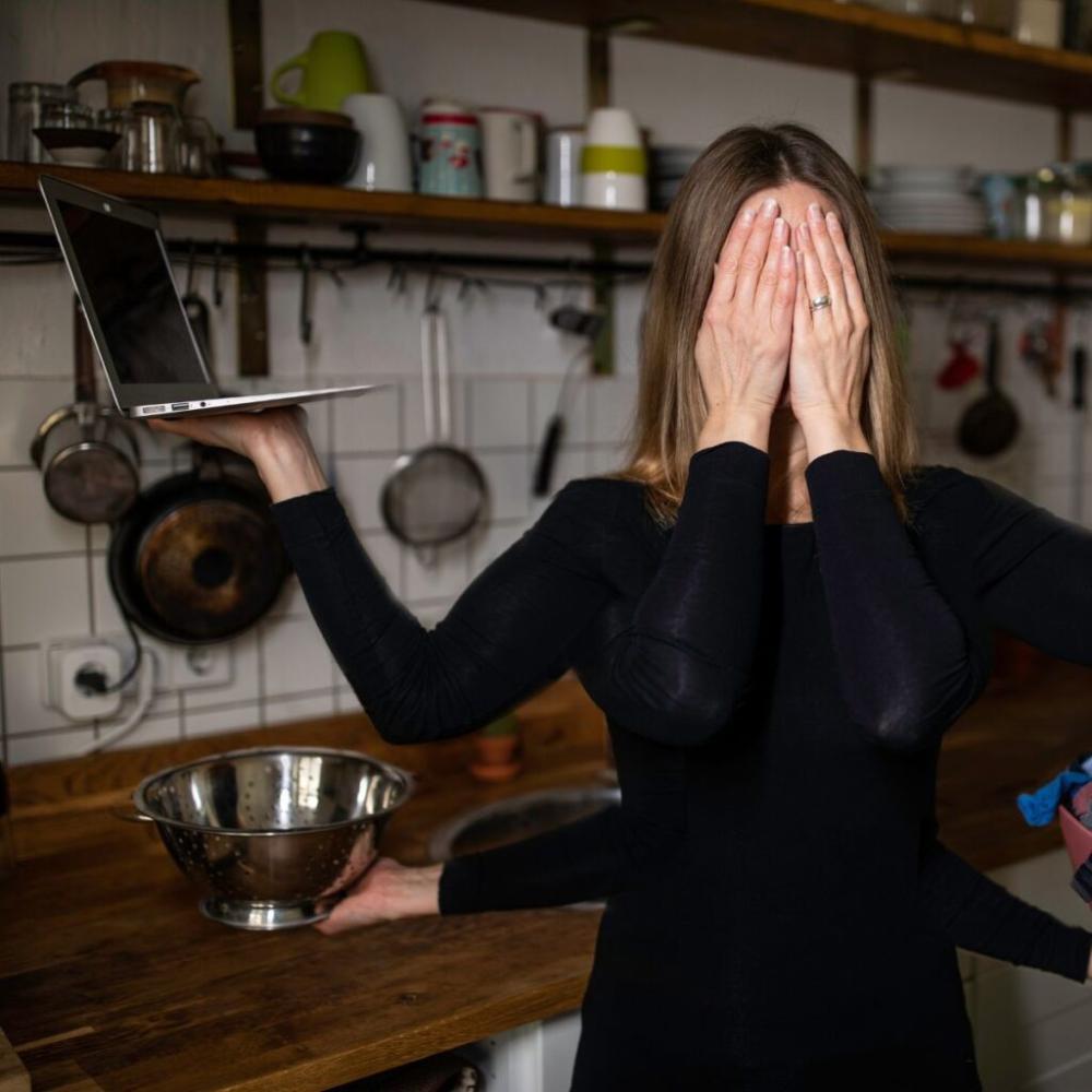Household Systems Overwhelmed woman with many hands holding laptop, bowl with extra hands over eyes.